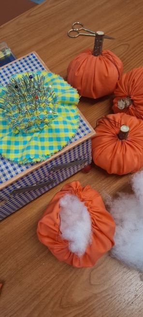Material zum Basteln liegen auf dem Tisch. Die ersten Kürbisse sind gebastelt.